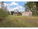 View of house and detached garage shed from the green grass backyard at 8476 Old Georgetown Rd, McClellanville, SC 29458