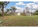 View of house and detached garage shed from the green grass backyard at 8476 Old Georgetown Rd, McClellanville, SC 29458