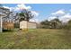 View of house and detached garage shed from the spacious grass backyard at 8476 Old Georgetown Rd, McClellanville, SC 29458