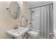 Bright bathroom featuring a sink, toilet, and tub/shower with white tile surround at 8476 Old Georgetown Rd, McClellanville, SC 29458