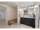 Bathroom features a double vanity with marble countertop, decorative bench, and neutral tile floor at 8476 Old Georgetown Rd, McClellanville, SC 29458