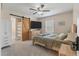 Bedroom featuring a ceiling fan, flat-screen TV, and ensuite bathroom with sliding barn door at 8476 Old Georgetown Rd, McClellanville, SC 29458