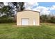 New metal building with white door and trim, set on a green lawn under a sunny sky at 8476 Old Georgetown Rd, McClellanville, SC 29458