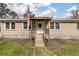 Inviting home entrance with a covered front porch, wooden steps, a wreath on the door, and charming details at 8476 Old Georgetown Rd, McClellanville, SC 29458