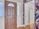 Home foyer with a decorative front door, hardwood floors, and elegant wallpaper design at 8774 Adaline St, North Charleston, SC 29406