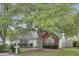 Inviting home with beautiful shade trees, manicured bushes, and brick accents create a comfortable setting at 8774 Adaline St, North Charleston, SC 29406