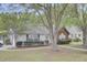 Quaint home showcasing established landscaping, beautiful trees, and a serene neighborhood setting at 8774 Adaline St, North Charleston, SC 29406