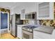 Kitchen featuring stainless steel appliances, white cabinets, and dark floral wallpaper at 8774 Adaline St, North Charleston, SC 29406