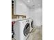 Bright laundry room with white cabinets, countertop, and modern washer and dryer at 8774 Adaline St, North Charleston, SC 29406