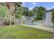 Backyard view showcasing the in-ground pool, surrounded by lush green grass and mature palm trees at 8774 Adaline St, North Charleston, SC 29406