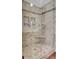 Shower featuring neutral stone-look tile, built-in seat and inset shelf at 8774 Adaline St, North Charleston, SC 29406