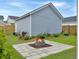 Landscaped backyard features a stone fire pit and lush greenery, ideal for outdoor entertaining at 886 Clay Field Trl, Summerville, SC 29485