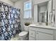 Bright bathroom featuring a shower with patterned curtain, white vanity, and a toilet at 886 Clay Field Trl, Summerville, SC 29485