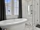 Modern bathroom featuring a freestanding tub and a glass-enclosed shower with window at 886 Clay Field Trl, Summerville, SC 29485