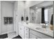 Elegant bathroom featuring double sinks with white cabinetry, a large mirror, and a glass enclosed shower at 886 Clay Field Trl, Summerville, SC 29485