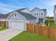 Blue house with a detached garage, fenced backyard, and well manicured lawn at 886 Clay Field Trl, Summerville, SC 29485
