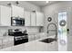 Bright kitchen with white cabinets, a large island, and stainless steel appliances at 886 Clay Field Trl, Summerville, SC 29485