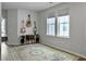 Bright living room featuring a decorative rug, guitars, and natural light from two windows at 886 Clay Field Trl, Summerville, SC 29485