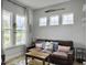 Living room features a comfortable leather couch and large windows at 886 Clay Field Trl, Summerville, SC 29485