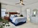 Cozy bedroom with wooden furniture, ceiling fan, and blue bedding next to bathroom at 886 Clay Field Trl, Summerville, SC 29485