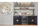 Stylish bar area features a wine fridge, shelving, custom cabinetry, and unique artwork at 9822 Haven Loop, Johns Island, SC 29455