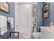 Bright bathroom features blue accent wall, white subway tile in shower, hexagon tile floors and floral shower curtain at 9822 Haven Loop, Johns Island, SC 29455