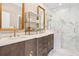 Bright bathroom featuring marble walk-in shower, double vanity with gold accents, and linen wallpaper at 9822 Haven Loop, Johns Island, SC 29455
