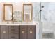 Bright bathroom featuring marble walk-in shower, double vanity with gold accents, and linen wallpaper at 9822 Haven Loop, Johns Island, SC 29455