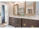 Bright bathroom featuring marble walk-in shower, double vanity with gold accents, and linen wallpaper at 9822 Haven Loop, Johns Island, SC 29455