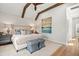 Spacious bedroom with exposed beams, light colors, upholstered bed and accent pillows at 9822 Haven Loop, Johns Island, SC 29455