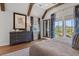 Bedroom with exposed beams, hardwood floors, blue patterned curtains, and lots of natural light at 9822 Haven Loop, Johns Island, SC 29455