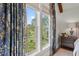Large windows adorned with patterned blue curtains let sunlight illuminate the peaceful bedroom at 9822 Haven Loop, Johns Island, SC 29455