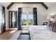 Spacious bedroom with exposed beams, light colors, upholstered bed and accent pillows at 9822 Haven Loop, Johns Island, SC 29455