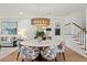 Dining area with a round marble table, patterned chairs, modern lighting fixture and stairs in the background at 9822 Haven Loop, Johns Island, SC 29455