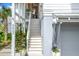 Charming home entryway with wooden stairs, potted plants, and a gray garage at 9822 Haven Loop, Johns Island, SC 29455