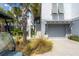 Charming home exterior featuring a gray garage, stairway, and palm tree landscaping at 9822 Haven Loop, Johns Island, SC 29455