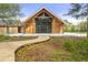 Striking exterior with a wooden walkway leading up to a modern farmhouse with large windows at 9822 Haven Loop, Johns Island, SC 29455