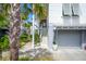 Home exterior featuring wood siding, a stairway, and a gray garage with palm trees at 9822 Haven Loop, Johns Island, SC 29455