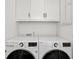 Modern laundry room with white cabinets, a front-load washer, and a front-load dryer at 9822 Haven Loop, Johns Island, SC 29455