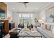 Bright living room featuring a fireplace, hardwood floors, modern furnishings, and a large window with backyard view at 9822 Haven Loop, Johns Island, SC 29455