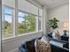 Living room detail showcasing a large window with scenic backyard views, stylish curtains, and comfortable seating at 9822 Haven Loop, Johns Island, SC 29455