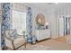 Stylish living room featuring blue patterned curtains, an ornate chair, and a decorative cabinet with vases at 9822 Haven Loop, Johns Island, SC 29455