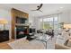 Bright living room featuring a fireplace, hardwood floors, modern furnishings, and a large window with backyard view at 9822 Haven Loop, Johns Island, SC 29455