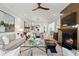 Bright living room featuring a fireplace, hardwood floors, modern furnishings, and an open concept design leading to the kitchen at 9822 Haven Loop, Johns Island, SC 29455