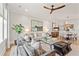 Living room featuring modern furnishings and hardwood floors that lead to a dining area with a round table and stairs in the background at 9822 Haven Loop, Johns Island, SC 29455