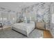 Bright bedroom features patterned wallpaper, hardwood floors, a patterned rug and two side tables with lamps at 9822 Haven Loop, Johns Island, SC 29455