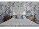 Bright bedroom features patterned wallpaper, two side tables with lamps, and three decorative pillows on the bed at 9822 Haven Loop, Johns Island, SC 29455