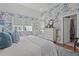 Bright bedroom features patterned wallpaper, wood floors, and a view into the home's bathroom at 9822 Haven Loop, Johns Island, SC 29455