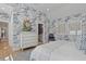 Bright bedroom features patterned wallpaper, wood floors, a patterned rug and a chest of drawers at 9822 Haven Loop, Johns Island, SC 29455
