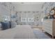 Bright bedroom features patterned wallpaper, hardwood floors, a patterned rug and a chest of drawers at 9822 Haven Loop, Johns Island, SC 29455